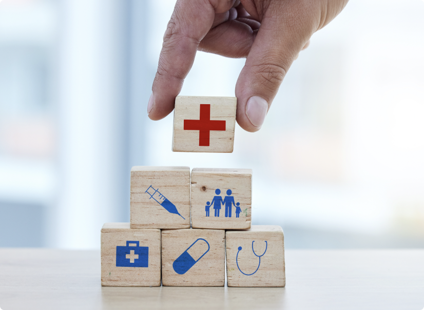 Hand placing wooden blocks with healthcare iconography