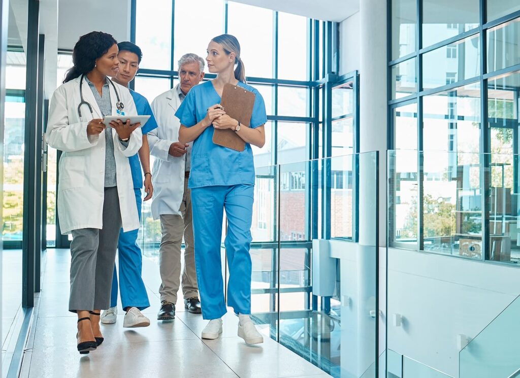 Group of doctors walking down hallway discussing patients